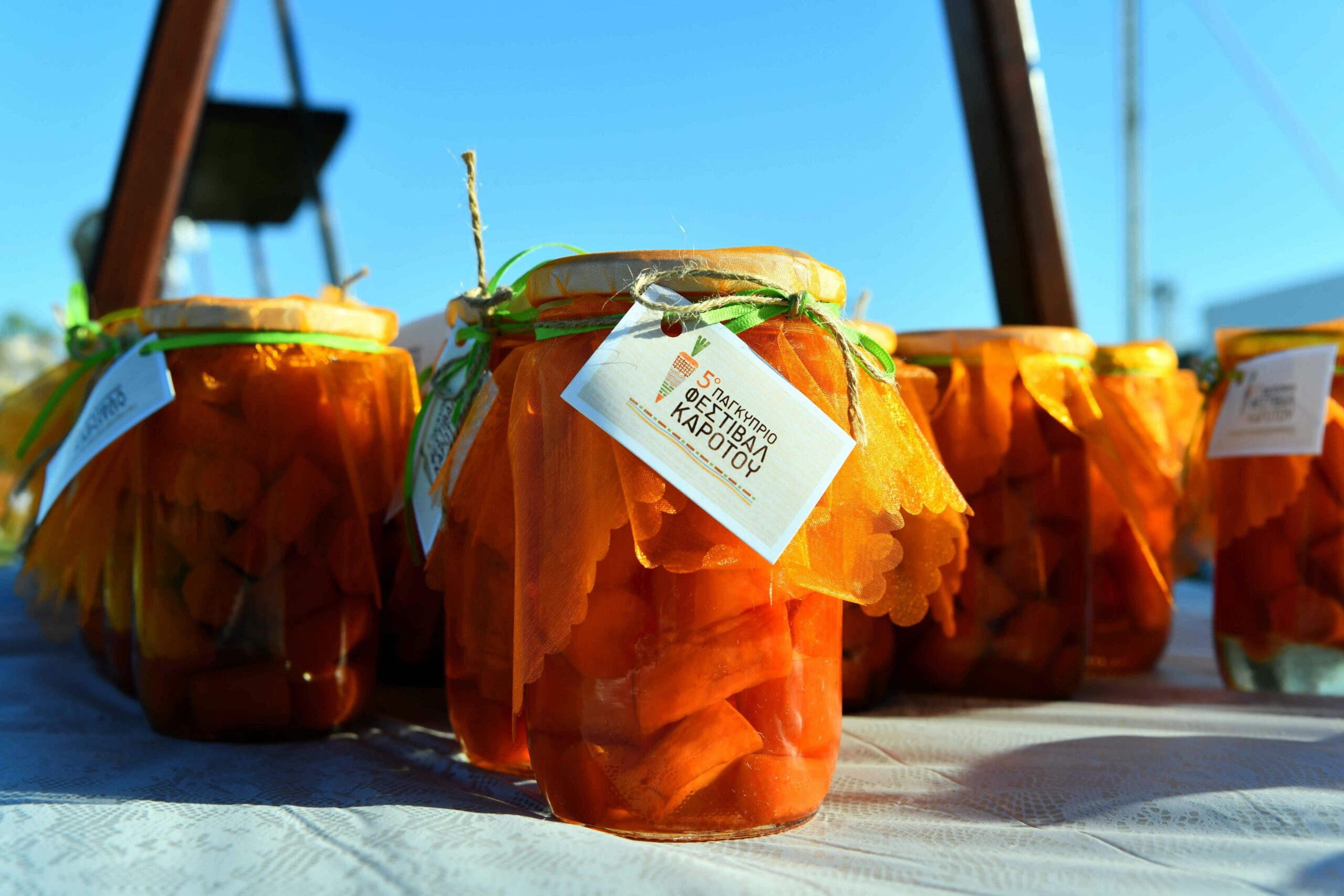 Several small glass jars stocked neatly with almond clusters, dried mango strips, and pumpkin seeds.