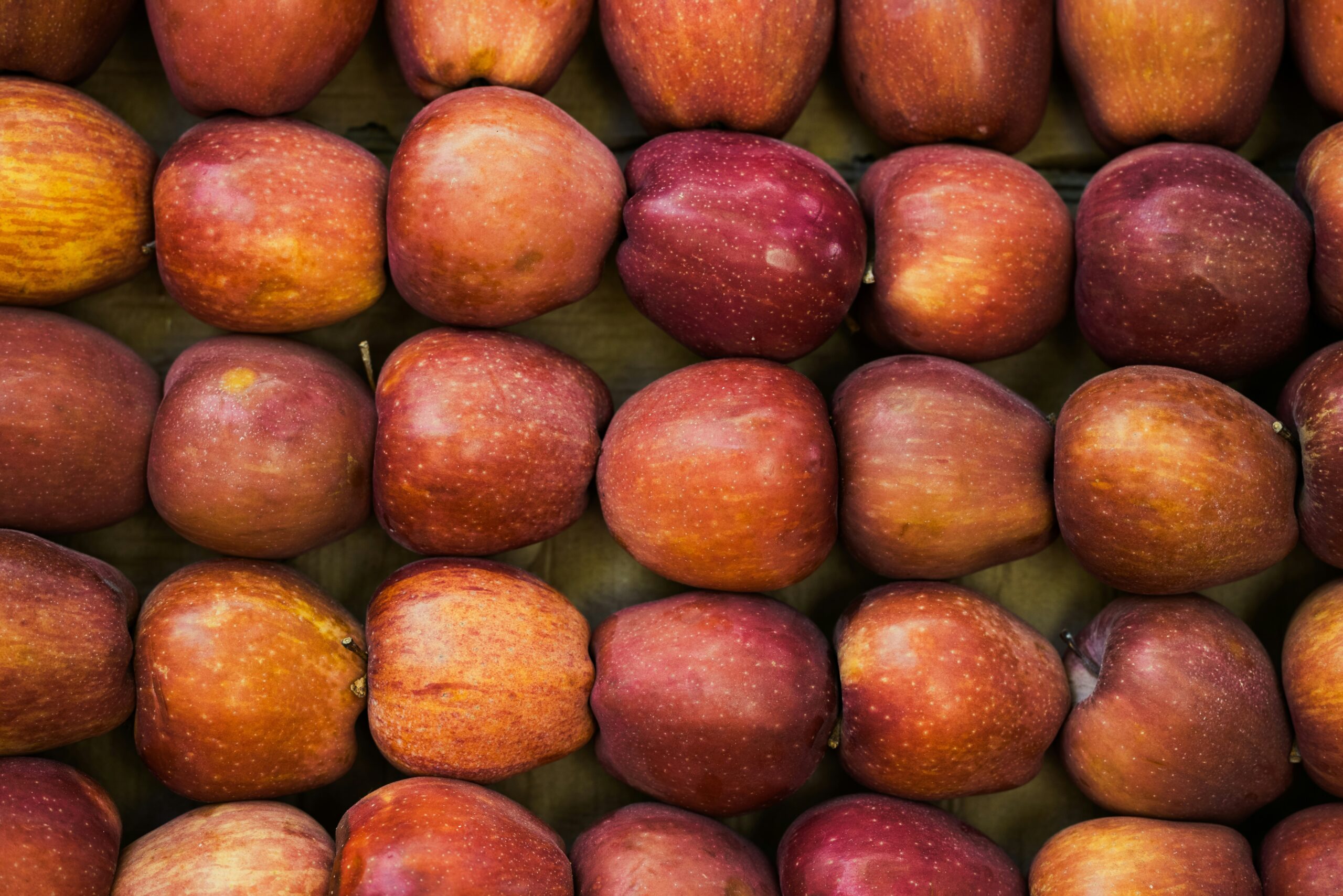 A kitchen counter lined with jars of pre-portioned snacks including almonds, trail mix, and apple slices.
