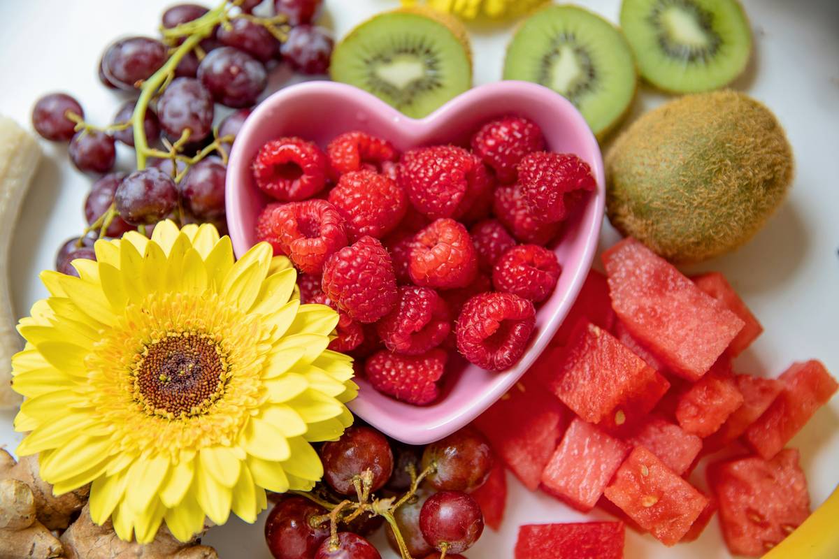 A colorful display of organic stone fruits including apricots, peaches, and plums arranged on a wooden table.