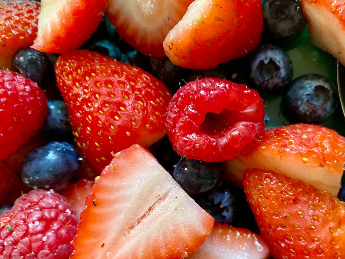 A green smoothie topped with organic hemp seeds in a glass jar on a marble countertop.