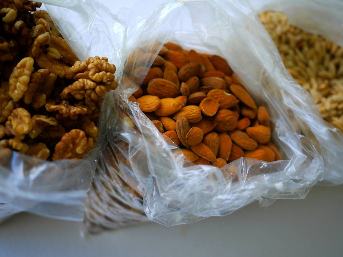 A wooden table showcasing organic snacks like almonds, dried fruits, and dark chocolate bars